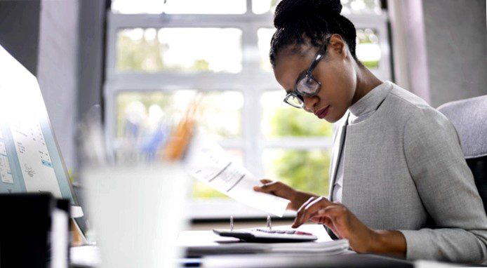 woman typing on calculator