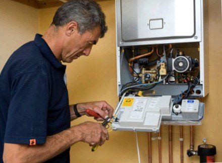 A man works on a gas boiler